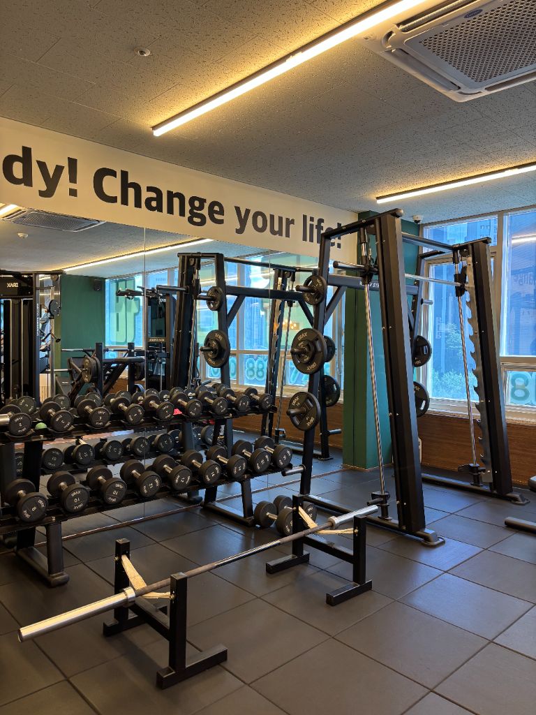 닥터바디짐 양주 옥정점 프리웨이트 존 - 덤벨 랙과 스미스머신, 벽면에 Change your life 문구
